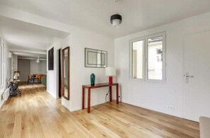 Enter a welcoming hallway leading to a dining area with a table and chairs.