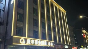 A hotel with illuminated signage and vertical light strips. - Yuanle Hotel (Boluo)