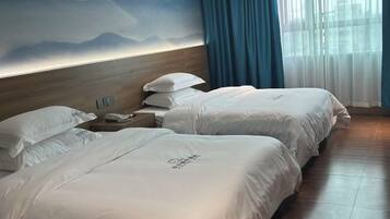 Habitación de hotel con dos camas, cabecero de madera, mesita de noche con teléfono y un mural con vistas a la montaña.