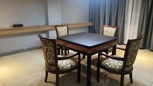 A dining area with a square table and four chairs with patterned upholstery. - Yuanle Hotel (Boluo)