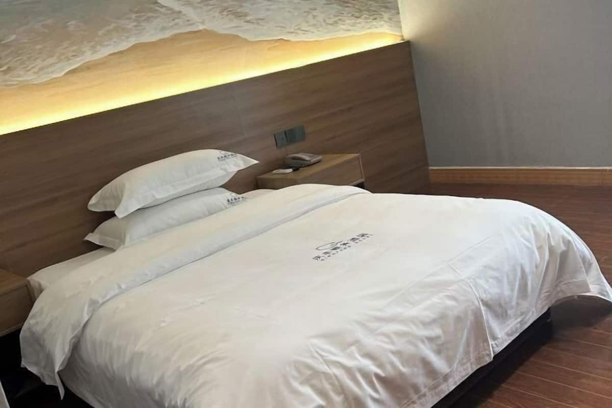 Una cama bien hecha con sábanas blancas y cabecera de madera.