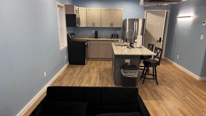 A compact living space with a kitchenette, a dining area, and a seating area.