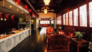 A traditional interior with a reception desk, wooden furniture, and decorative lanterns. - Shanghecheng Hotel (Feixi)