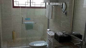 Un baño moderno con cabina de ducha de vidrio, inodoro, lavabo y espejo.