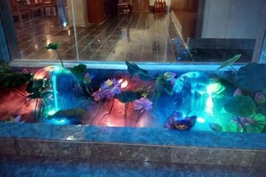 A decorative indoor water feature with plants and lights. - Shanghecheng Hotel (Feixi)