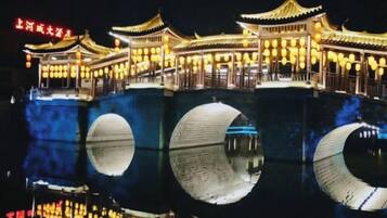 Un edificio chino tradicional de varios niveles con su reflejo en el agua.