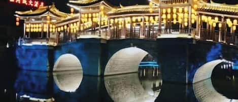 A traditional Chinese building with multiple levels and a reflection in the water.