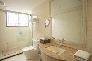 A modern bathroom with a glass shower enclosure, a toilet, a sink, and a large mirror. - Shanghecheng Hotel (Feixi)