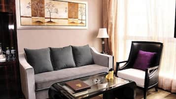A living room with a sofa, armchair, and coffee table.