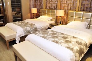 A hotel room with two beds, a bench, and a wooden headboard. - Ao Ni Si Hotel (Sanya)