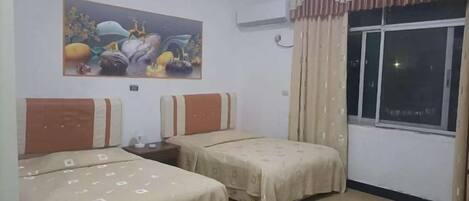 A hotel room with two beds, a painting on the wall, and a window with curtains.