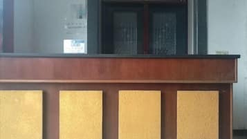A reception desk with a wooden finish and a glass panel.