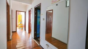 A hallway with wooden flooring and doors leading to different rooms. - Sunshine Hotel Xijing Hospital (Xi'an)