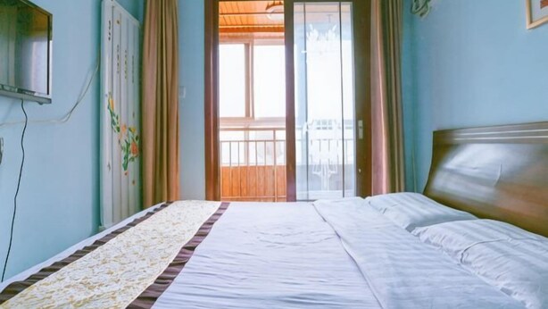 A bedroom with a bed, a window, curtains, and a radiator. - Sunshine Hotel Xijing Hospital (Xi'an)