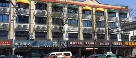 A multi-story building with various storefronts on the ground floor.