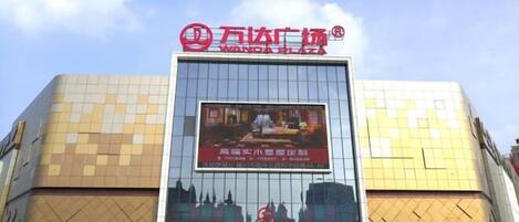 A building with a large sign reading "Wanda Plaza" and a Starbucks Coffee shop at the entrance.