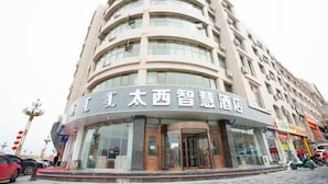 A multi-story hotel with a curved facade and large windows. - Inner Mongolia Too Western Coal Taixi Logistics Information (Alxa Left Banner)