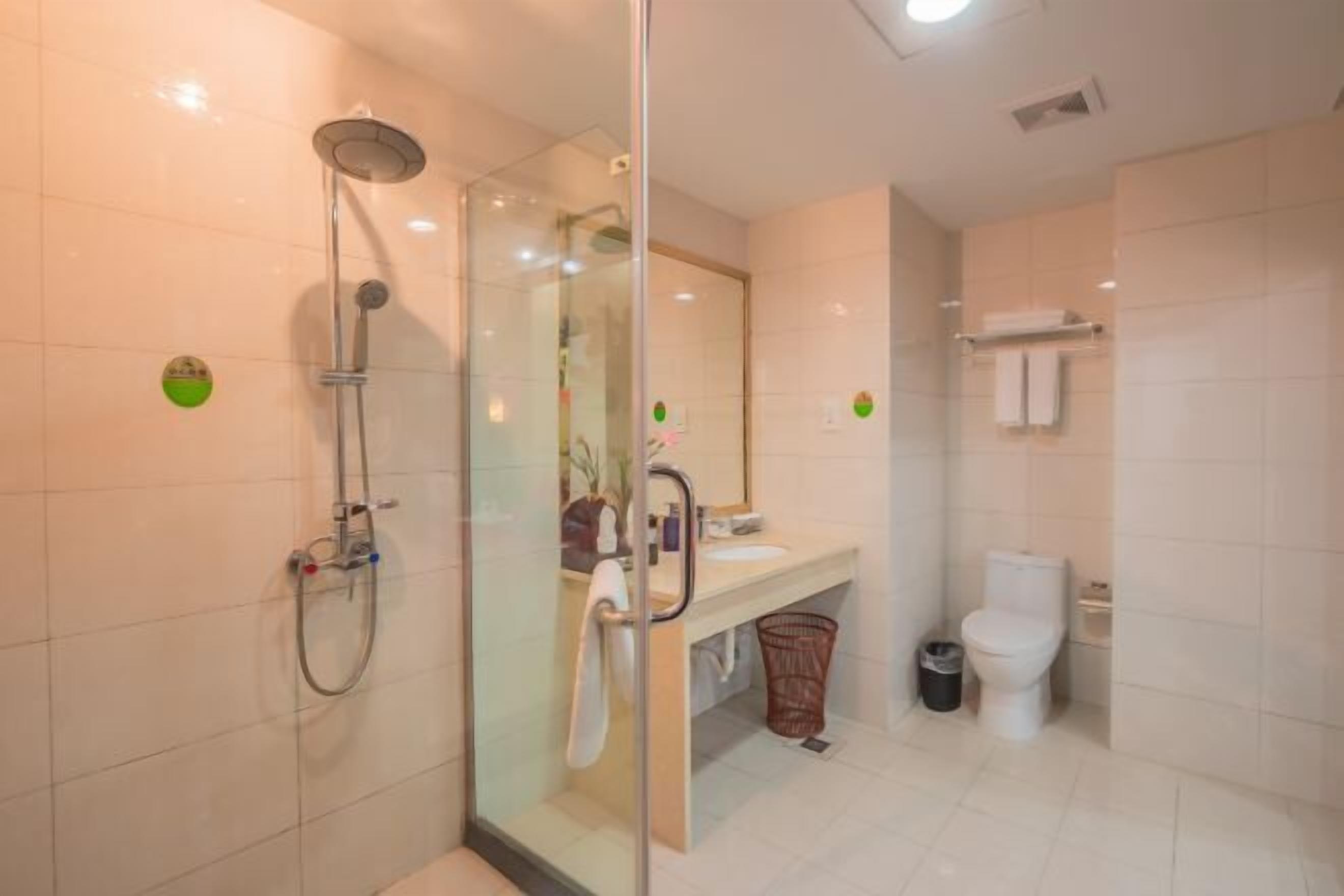 A modern bathroom with a glass-enclosed shower, a sink, and a toilet.