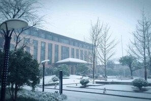 A building with a modern architectural style, surrounded by snow-covered trees and a clear sky. - Qing He Hotel (Hangzhou)