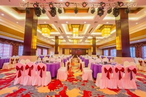 A banquet hall with rows of tables and chairs, a carpeted floor, and a chandelier. - Qing He Hotel (Hangzhou)