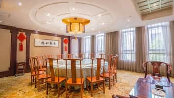 A conference room with a round table, chairs, and a chandelier.