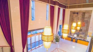 A hotel lobby with a high ceiling, large windows, and hanging lamps. - Qing He Hotel (Hangzhou)