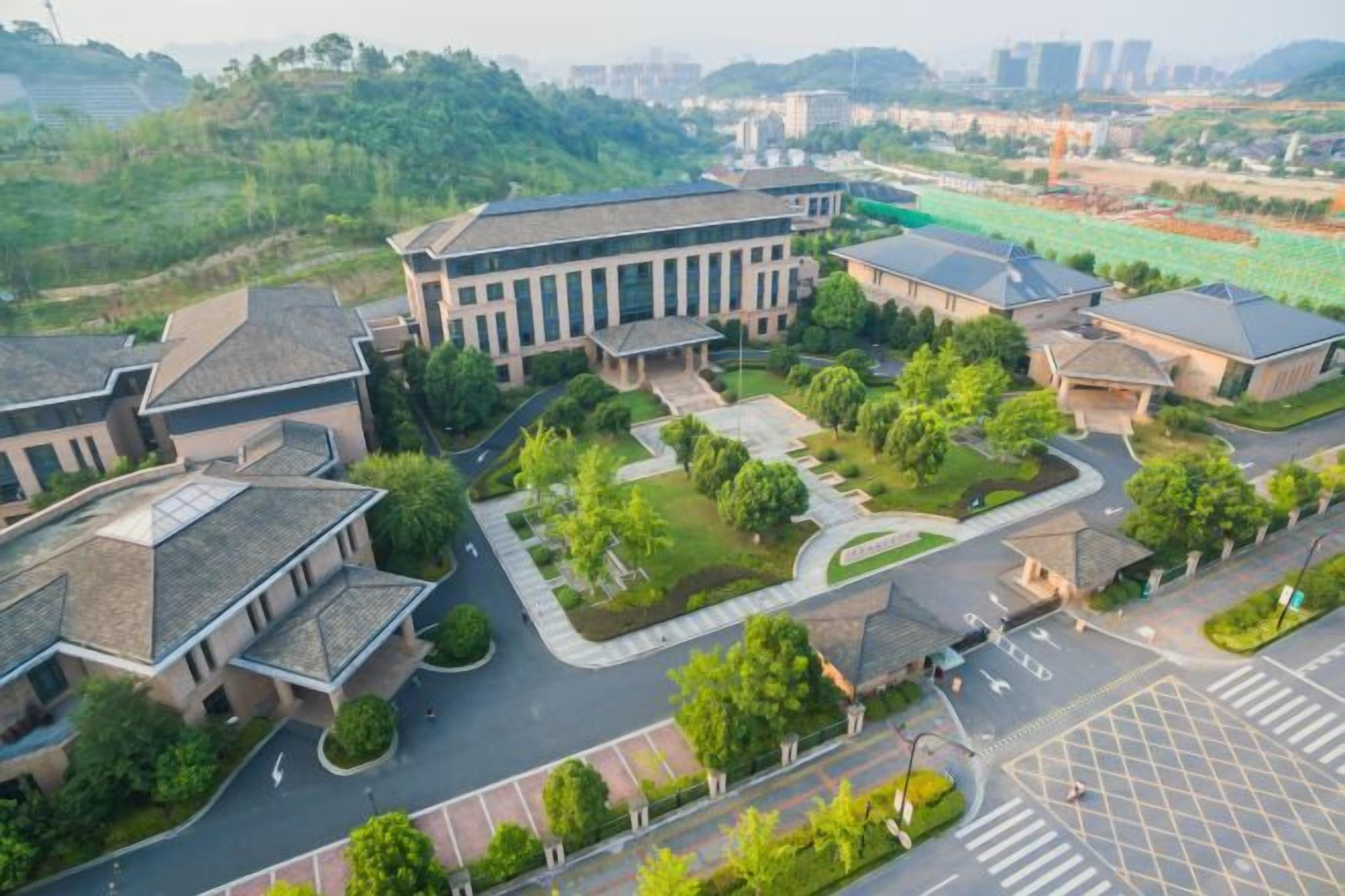A residential area with multiple buildings, a central courtyard, and a road.