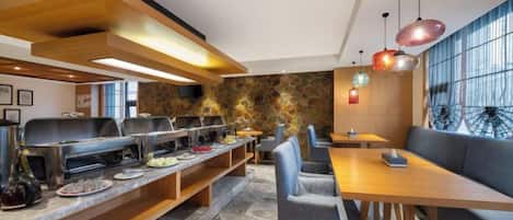 A modern dining area with multiple seating options, including a long communal table and individual booths.