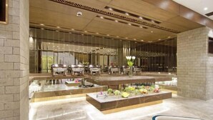 A modern hotel lobby with a central reception desk, seating area, and a large mirror reflecting the space. - Winford Resort and Casino Manila (City of Manila)