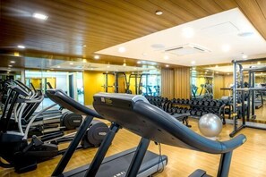 Ein Fitnessstudio mit Laufbändern, Crosstrainern und Gewichten.