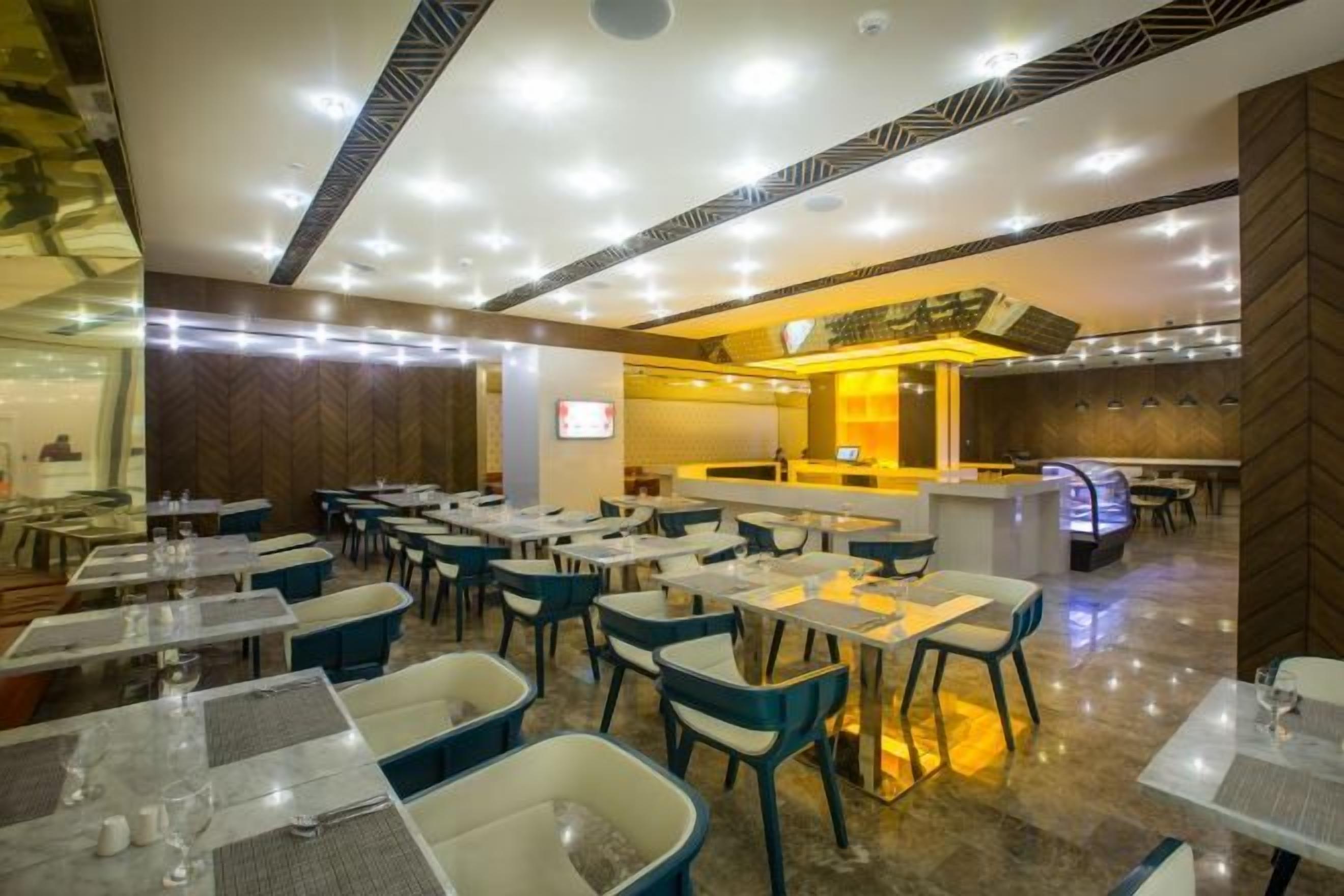 A restaurant with multiple tables and chairs, a bar area, and a counter.