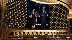 A conference room with a geometric patterned wall, rows of chairs, and a large screen displaying a presentation. - Winford Resort and Casino Manila (City of Manila)