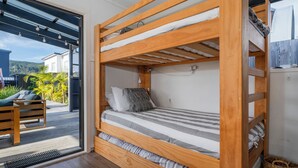 A bunk bed with a wooden frame, a small desk, and a chair.