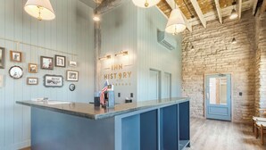 A reception desk with a sign reading "Inn History" and an American flag. There are framed pictures on the wall and a stone wall in the background.