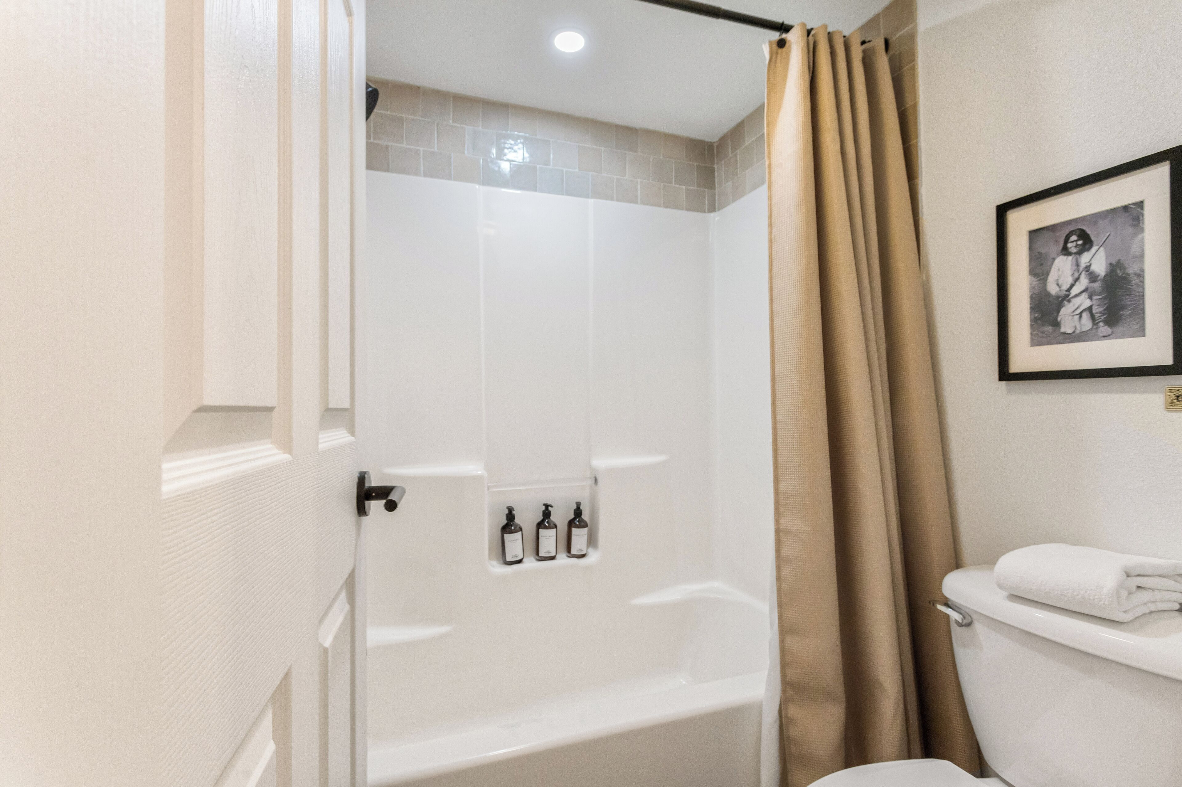 Un baño con bañera, inodoro y cortina de ducha.