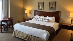 A hotel room with a large bed, two bedside tables, a desk with a chair, and two lamps. - Carriage Studio Retreat (Shanty Bay)