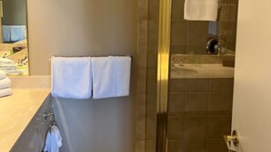 A modern bathroom with a glass-enclosed shower, a vanity with a mirror, and two towels hanging on the wall. - Carriage Studio Retreat (Shanty Bay)