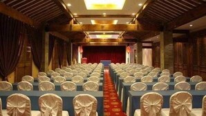 A conference room with rows of tables and chairs, a red carpet, and a stage at the front. - Auspicious Business (Beijing)