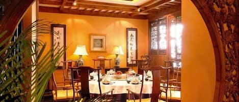 Un comedor tradicional con una mesa redonda, sillas y un arco decorativo.
