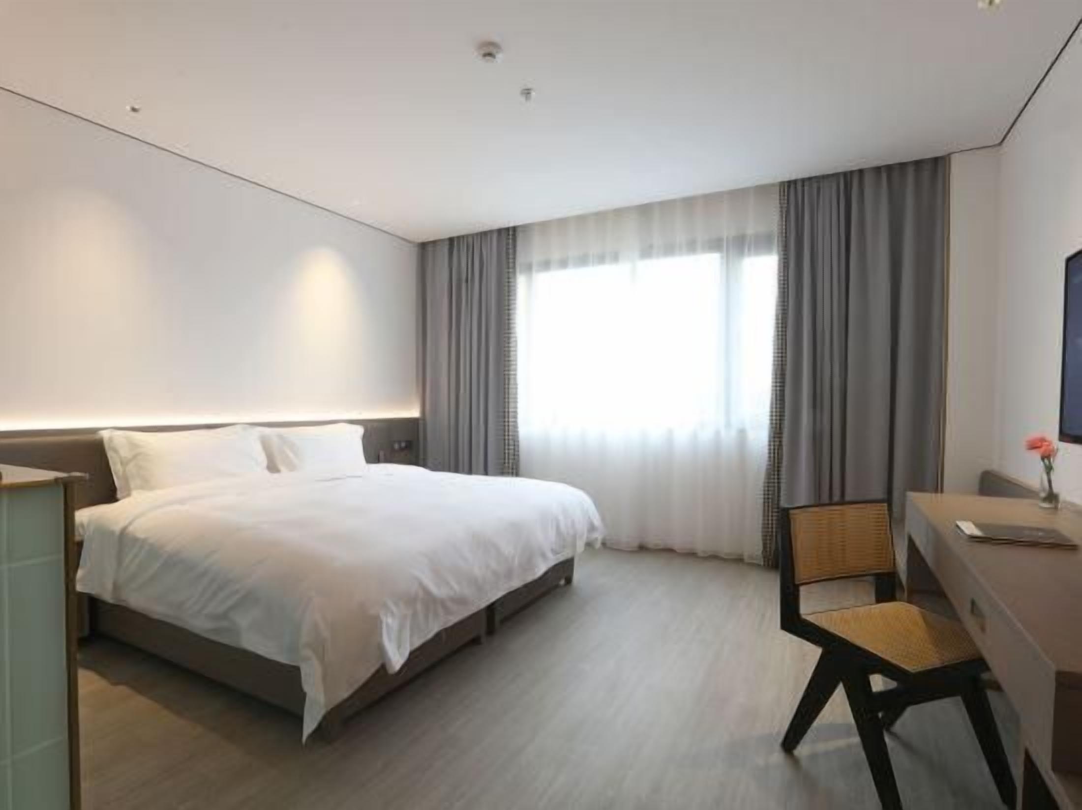 Una habitación de hotel con una cama, un escritorio y una silla.