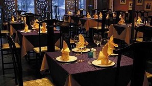 A restaurant with tables set for dining, featuring gold-colored chairs and purple tablecloths. - Auspicious Business (Beijing)