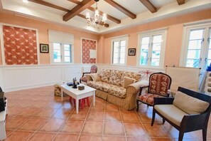 Una sala de estar amplia con sofá, sillas, una mesa de centro y una chimenea.