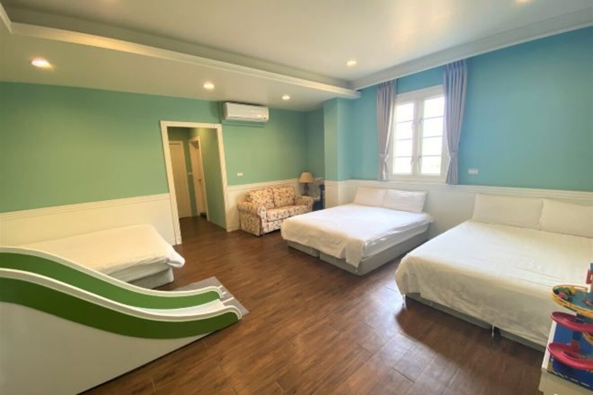 Une chambre avec deux lits, un canapé, une chaise et une petite table.