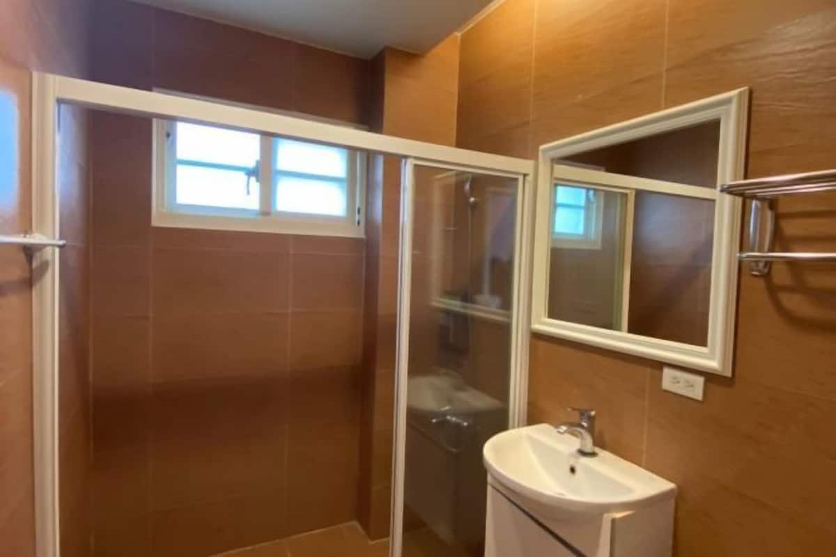 A bathroom with a shower, a sink, and a mirror.