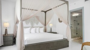 A modern bedroom with a four-poster bed, bedside lamps, and a glass-enclosed shower. - Townhouse Hotel (Miami Beach)