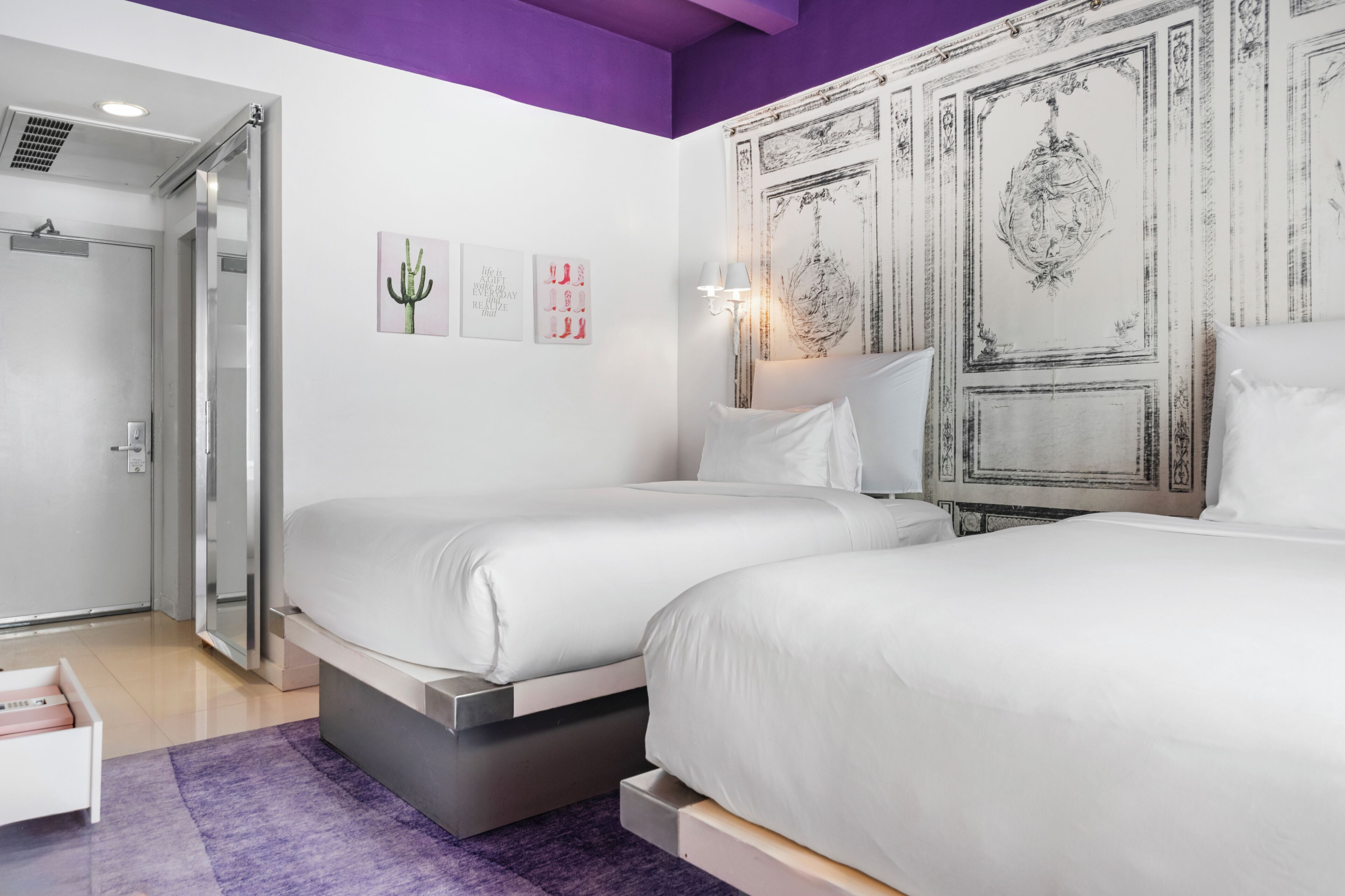 A modern bedroom with two beds, a walk-in closet, and a bathroom with a shower.