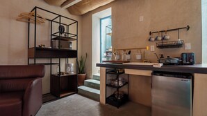 Una cocina moderna con lavavajillas integrado, estanterías de madera y una cafetera.