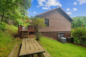 Une maison moderne avec un toit en pente, une terrasse en bois et un petit espace patio.
