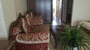 Ein Wohnzimmer mit einer Sofagarnitur, einem Couchtisch und einer Topfpflanze.