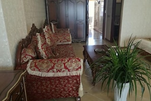 Una sala de estar con un sofá, una mesa de centro y una planta en maceta.